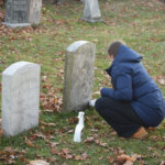 A student volunteer cleans a headstone in the Westville Cemetery on Nov. 20. Photos by Lily Rand