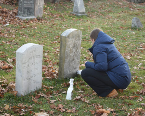 A student volunteer cleans a headstone in the Westville Cemetery on Nov. 20. Photos by Lily Rand